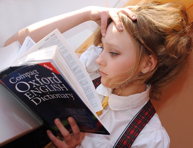فتاة تقرأ في قاموس أوكسفورد